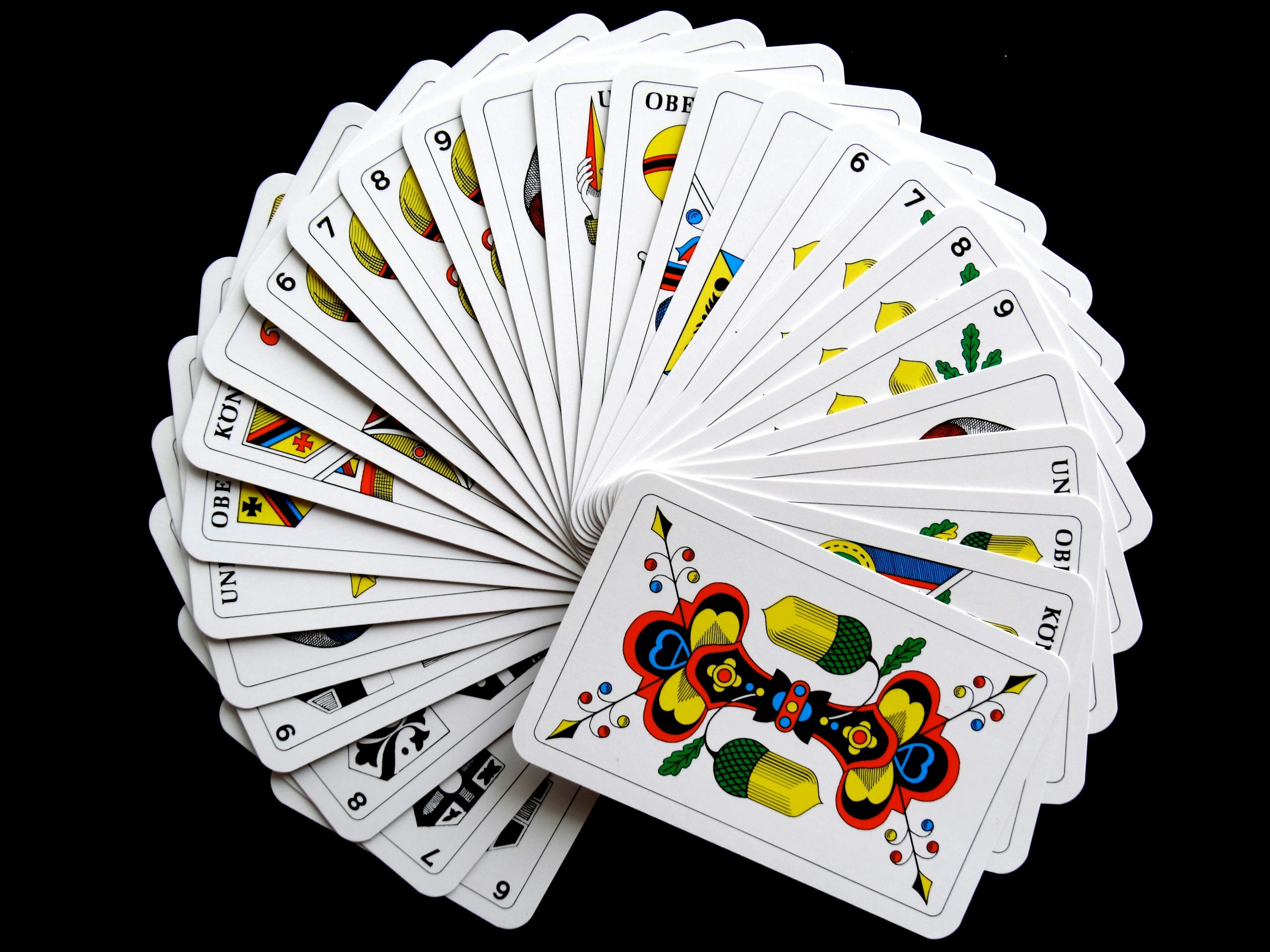 Vibrant and artistic playing cards fanned out against a black background.